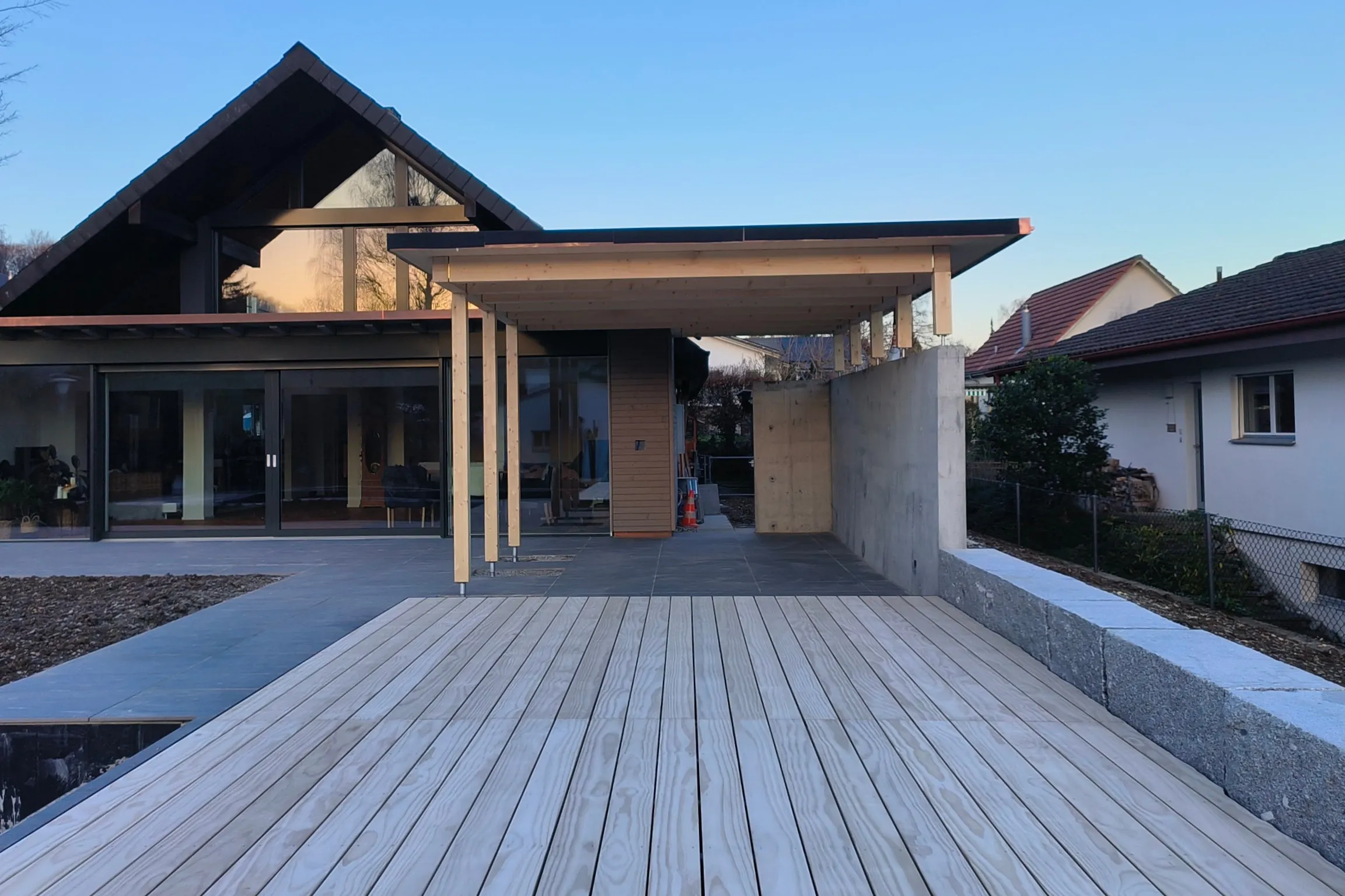 Grosse Terrasse aus Accoya-Holz vor einem Wohnhaus mit Vordach