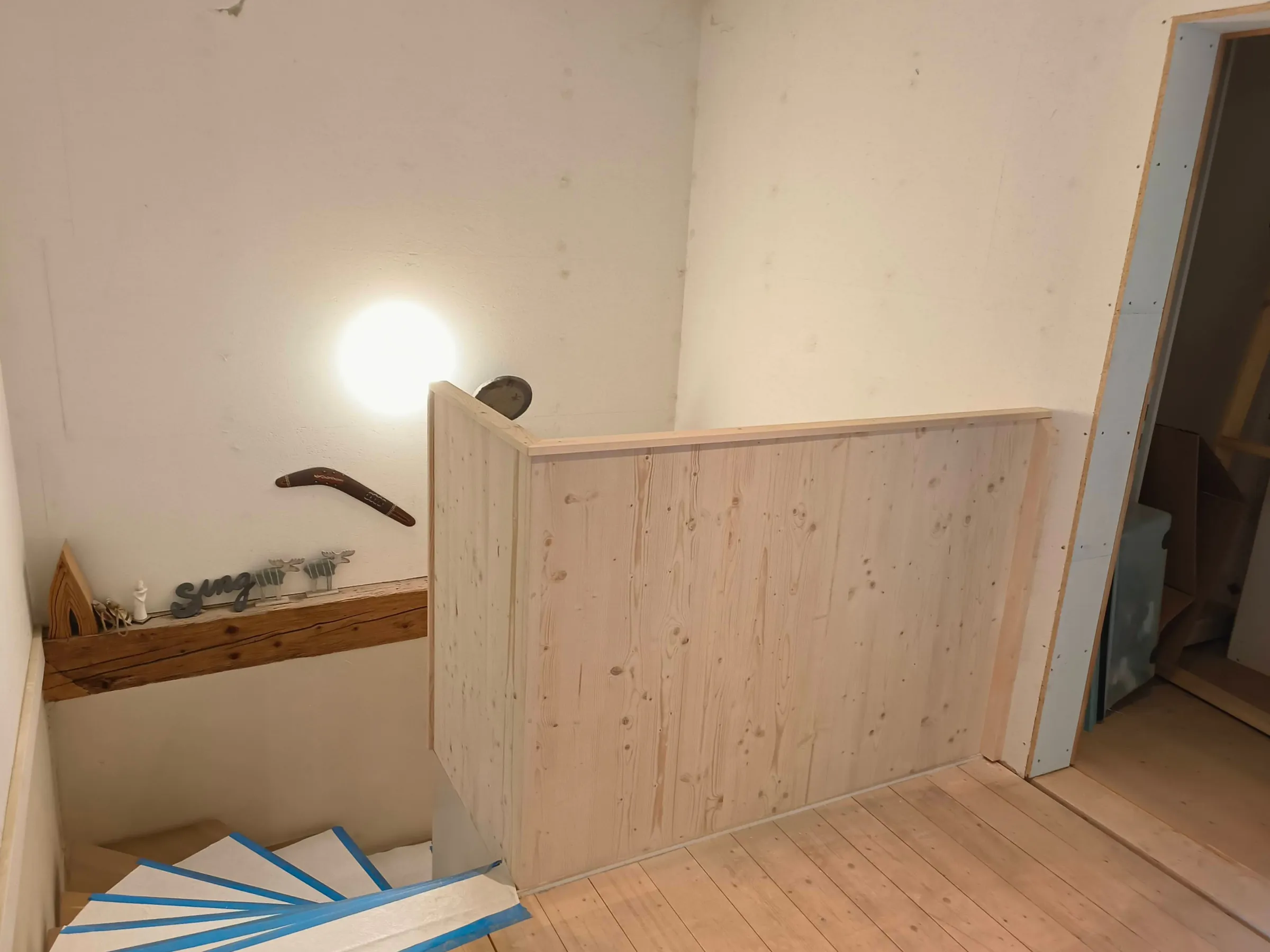 Treppenauge mit Brüstung aus hellen Fichtenbrettern, Holzboden und Treppenstufen