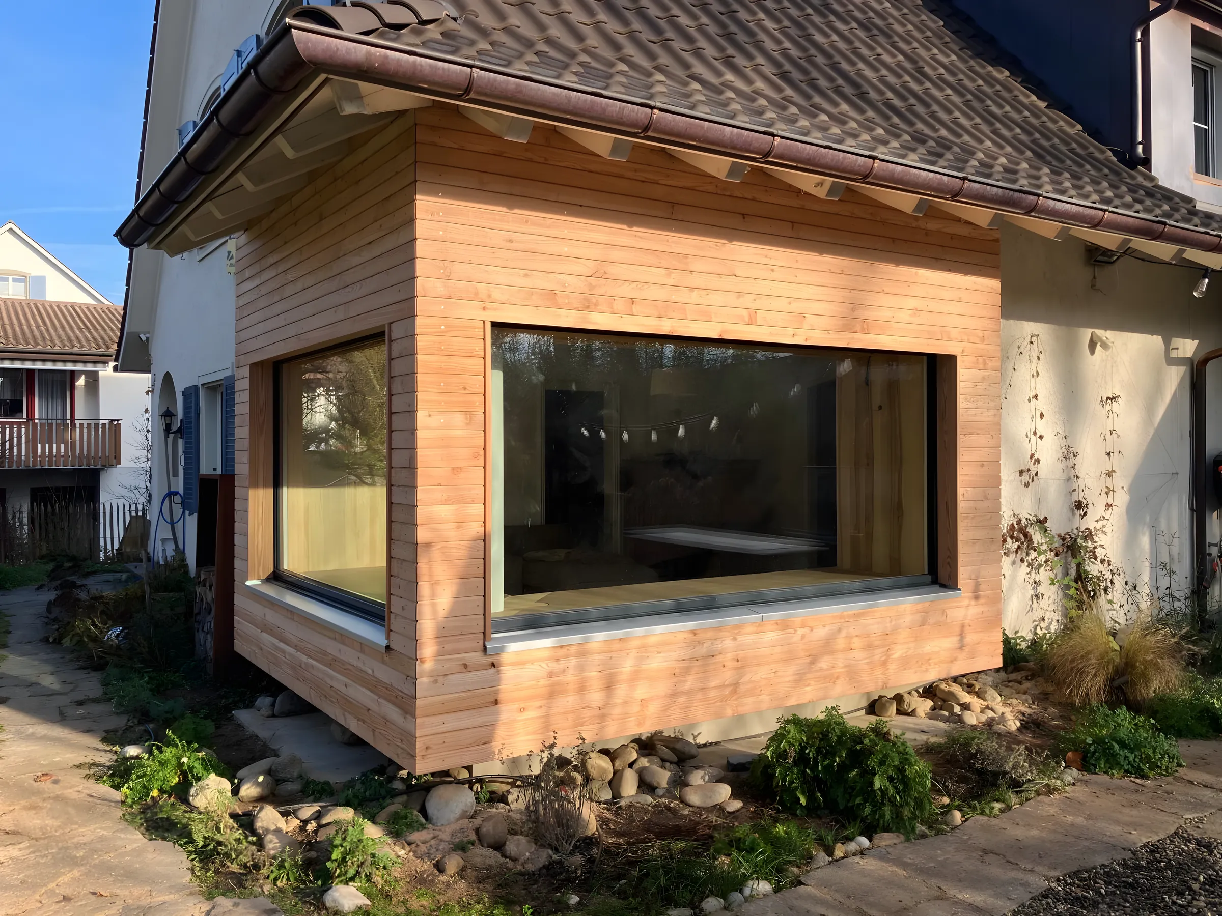 Neu aufgebauter Erker mit horizontaler Lärchenschalung und grossem Fenster in Liestal