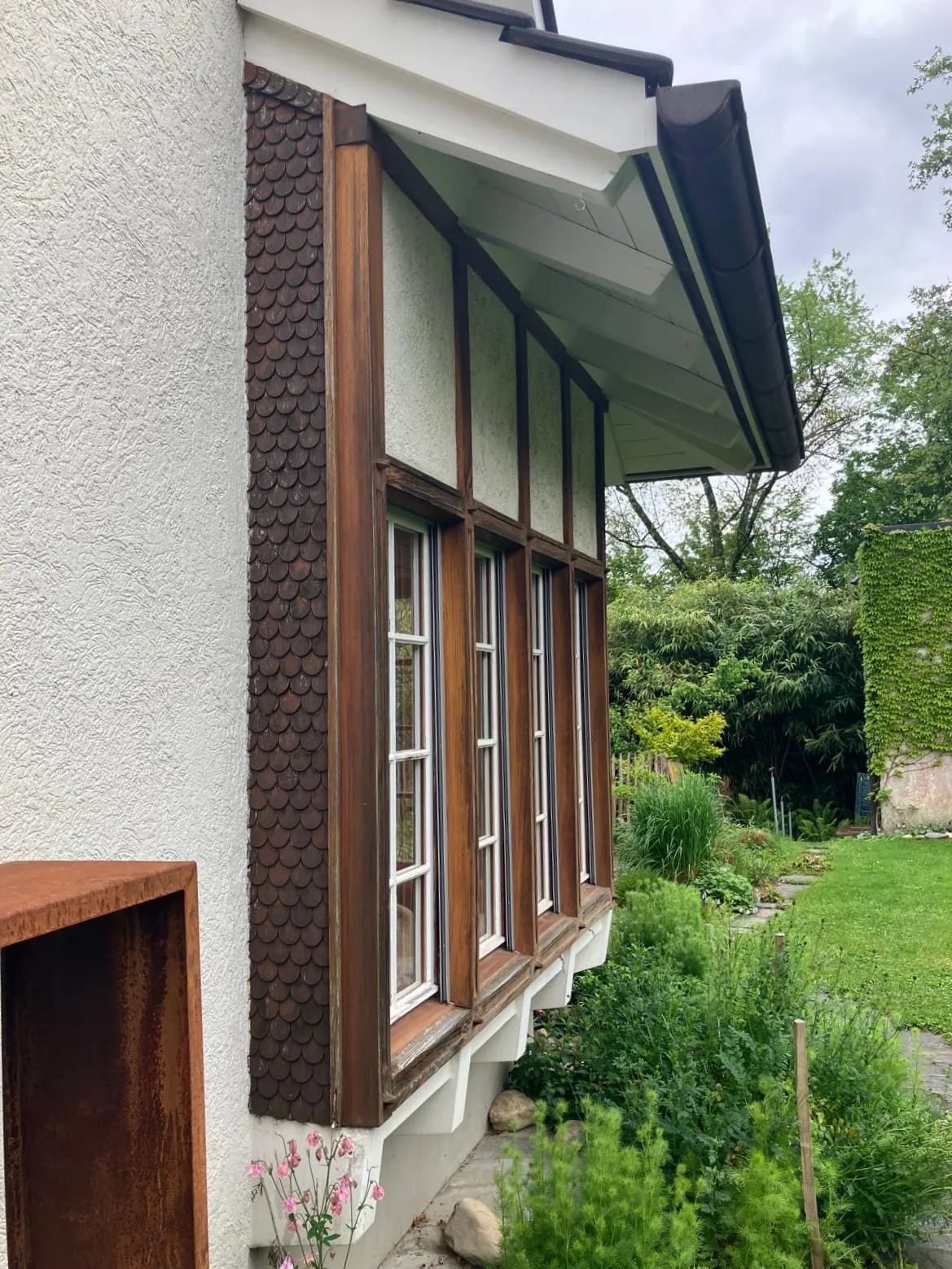 Alter Erker mit dunklen Holzschindeln und Sprossenfenstern vor der Sanierung in Liestal
