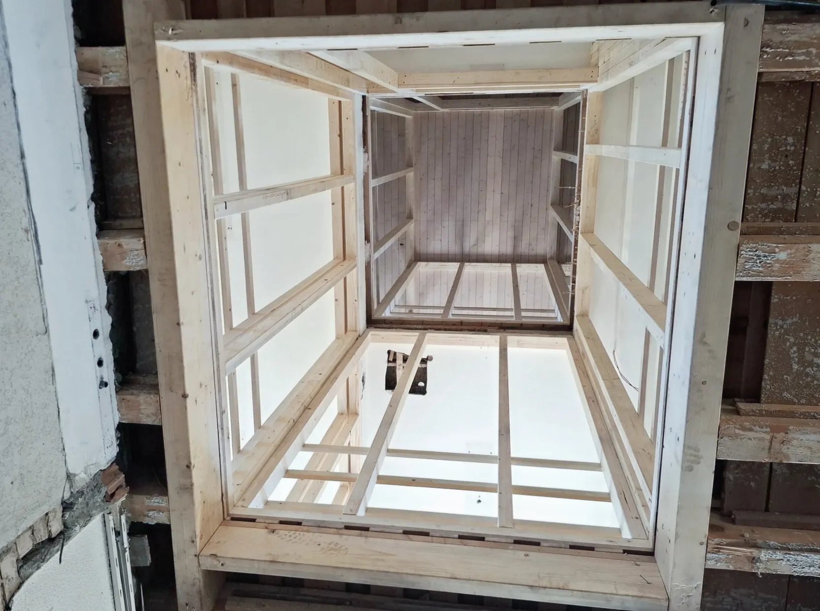 Vorbereiteter Liftschacht im Gemeindehaus Lupsingen von unten: Holzrahmen mit weissen Platten