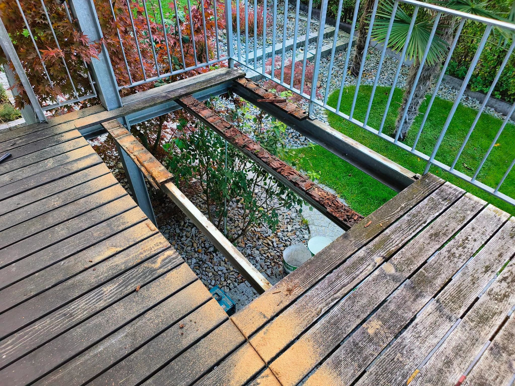 Balkon während der Demontage: alter Holzrost teilweise entfernt, darunter morsche Auflagerhölzer