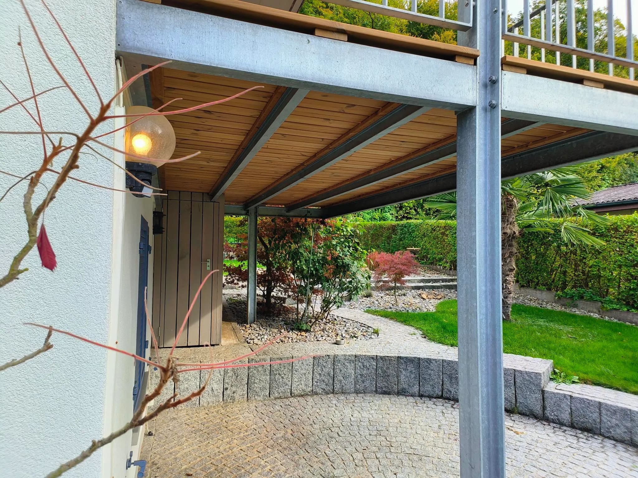 Untersicht des neuen Holzbalkonrosts zwischen den Stahlträgern über dem Sitzplatz im Garten