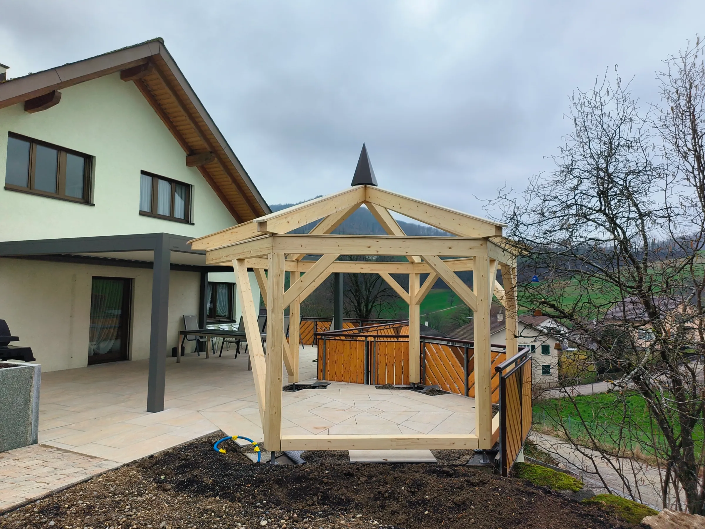 Sechseckige Pergola aus Fichte und Tanne auf der Terrasse eines Wohnhauses in Läufelfingen