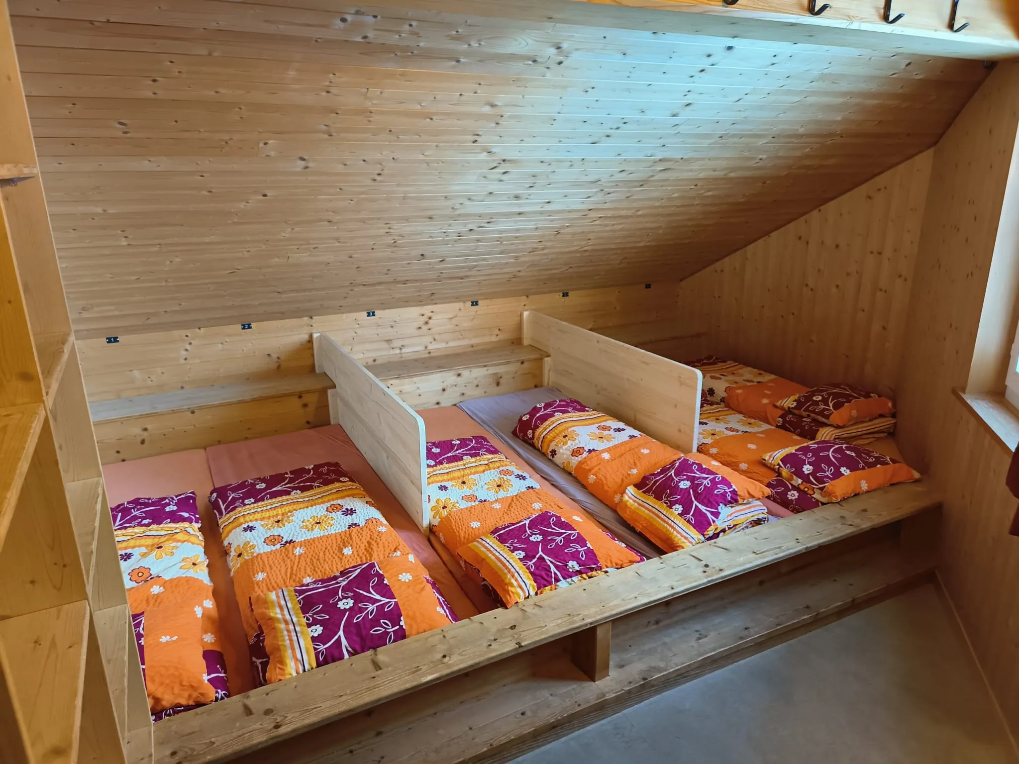 Massenlager der SAC-Hütte Tierbergli mit Holzkojen, Trennwänden und Täfer