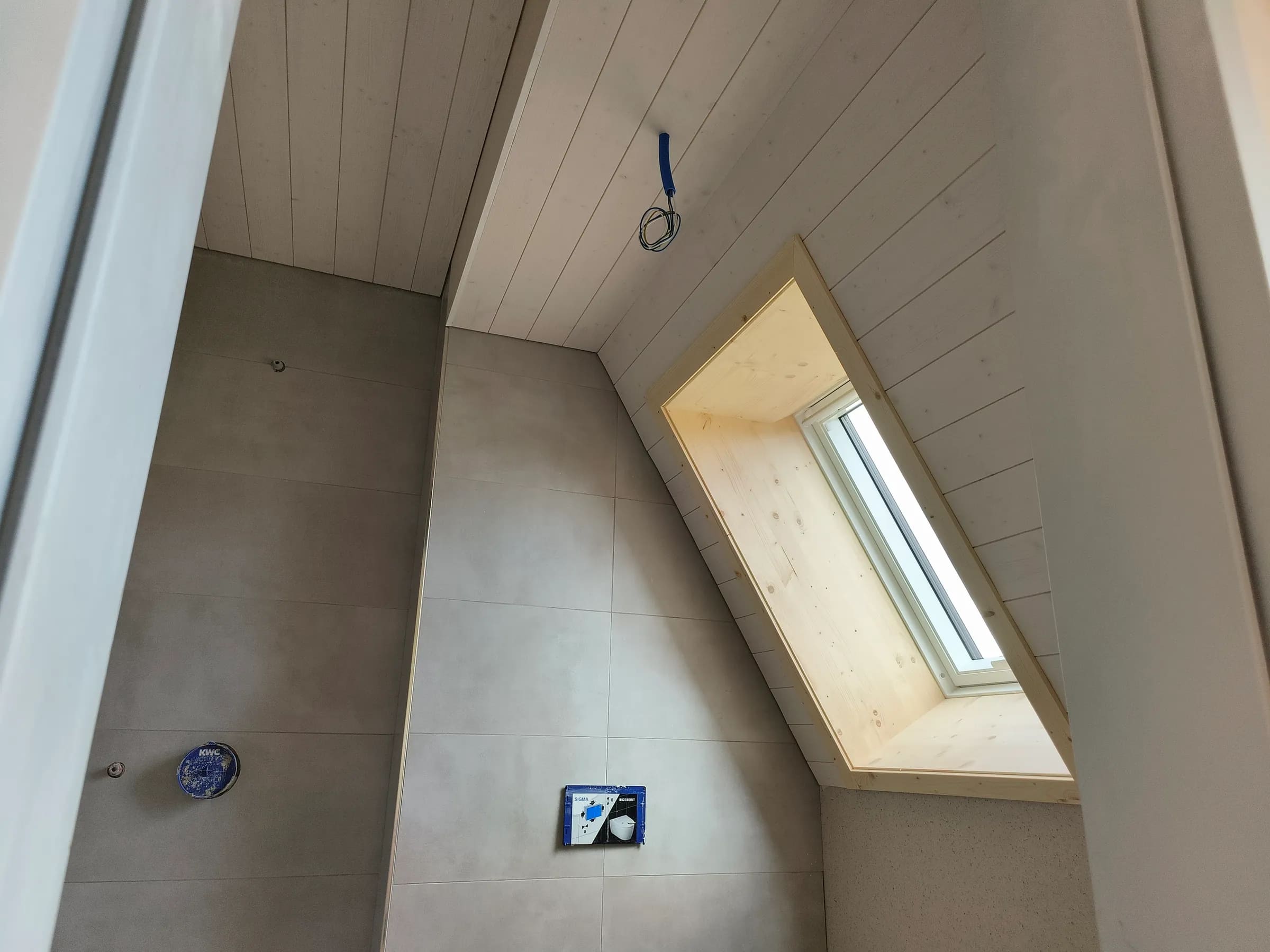 Velux-Dachfenster mit Innenfutter aus Holz und Täferdecke im Bad des Neubaus in Therwil